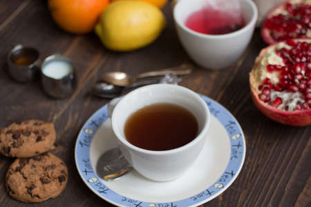 Fruit tea with, lemon, milk,honey,orange, pomegranate and brown sugar, on a wooden backgroundの写真素材