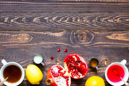 Fruit tea with, lemon, milk,honey,orange, pomegranate and brown sugar, on a wooden backgroundの写真素材