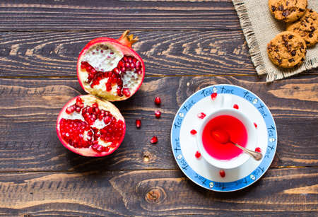 Fruit tea with, lemon, milk,honey,orange, pomegranate and brown sugar, on a wooden backgroundの写真素材