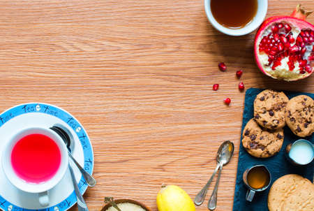Fruit tea with, lemon, milk,honey,orange, pomegranate and brown sugar, on a wooden backgroundの写真素材