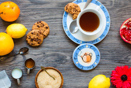 Fruit tea with, lemon, milk,honey,orange, pomegranate and brown sugar, on a wooden backgroundの写真素材