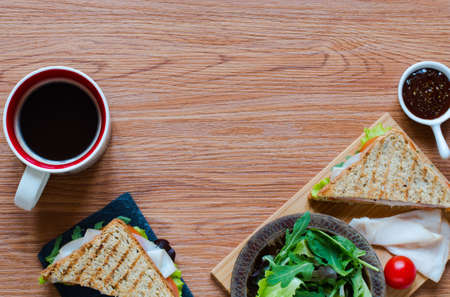 Top view of Healthy Sandwich toast with lettuce, ham, cheese and tomato on a wooden backgroundの写真素材