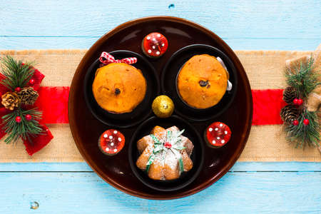Mini panettone with fruits and Christmas decoration, on different wood backgroundの写真素材