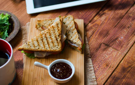 Top view of Healthy Sandwich toast with lettuce, ham, cheese and tomato on a wooden backgroundの写真素材
