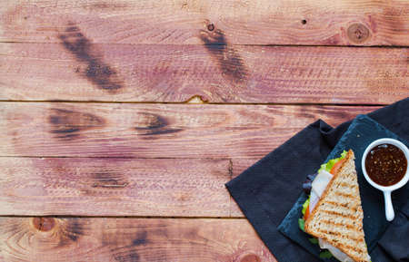Top view of Healthy Sandwich toast with lettuce, ham, cheese and tomato on a wooden backgroundの写真素材