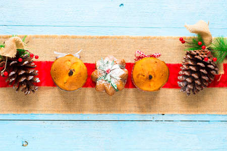Mini panettone with fruits and Christmas decoration, on different wood backgroundの写真素材