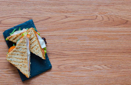 Top view of Healthy Sandwich toast with lettuce, ham, cheese and tomato on a wooden backgroundの写真素材