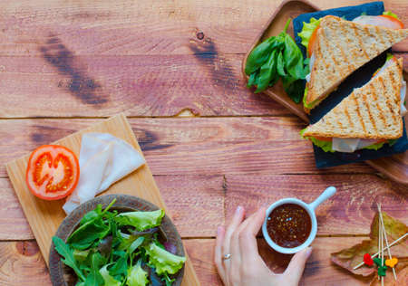 Top view of Healthy Sandwich toast with lettuce, ham, cheese and tomato on a wooden backgroundの写真素材