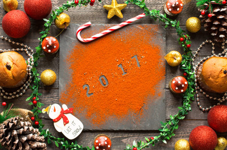 small panettone with fruits and Christmas decoration, on different wood background
