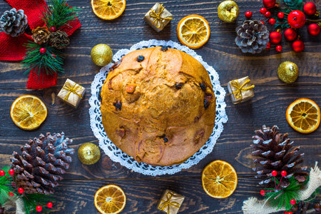 Panettone with fruit, orange, candied, raisins, and Christmas decoration, on a wooden backgroundの写真素材