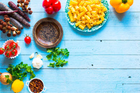 Top view of italian ingredients for spaghetti, with tomato, garlic, mushrooms,parsley, over a wood background.の写真素材