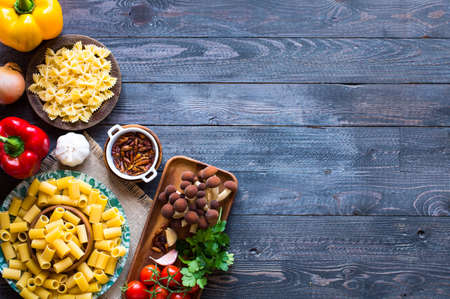 Top view of italian ingredients for spaghetti, with tomato, garlic, mushrooms,parsley, over a wood background.の写真素材