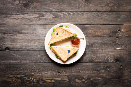 Top view of Healthy Sandwich toast with lettuce, ham, cheese, tomato and coffee, on a wooden backgroundの写真素材