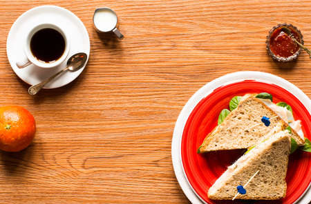 Top view of Healthy Sandwich toast with lettuce, ham, cheese, tomato and coffee, on a wooden backgroundの写真素材