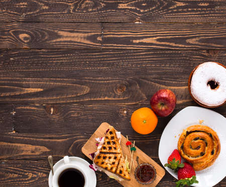 Top view of Healthy Sandwich toast with coffee,donuts, with fruits on a wooden backgroundの写真素材
