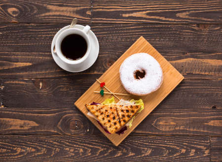 Top view of Healthy Sandwich toast with coffee,donuts, with fruits on a wooden backgroundの写真素材