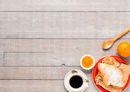 Coffee and croissant for breakfast, on rustic wooden table, top viewの写真素材