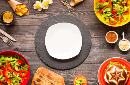 Top view of delicious hamburger, with vegetables and fries, on a wooden background.の写真素材