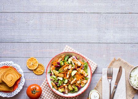 Salad of chicken breast with zucchini and cherry tomatoes, on a wooden background. top viewの写真素材