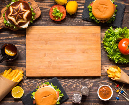 Top view of delicious hamburger, with vegetables and fries, on a wooden background.の写真素材