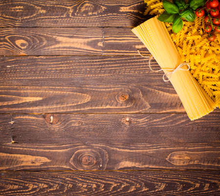 Close-up of decorating Italian pasta. Concept of traditional cuisine and healthy meal. On a wooden backgroundの写真素材