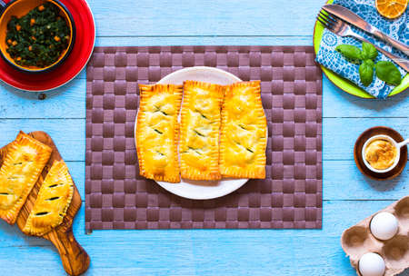 Delicious pie with spinach, made at home, on a wooden background, top viewの写真素材