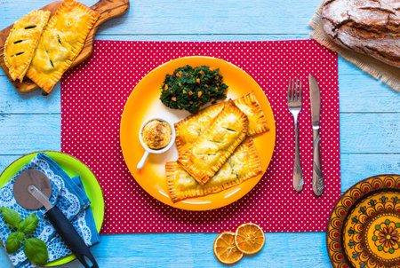 Delicious pie with spinach, made at home, on a wooden background, top view