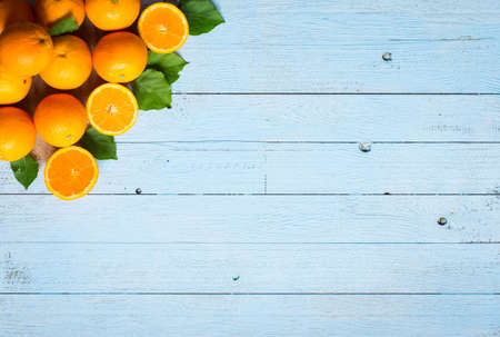 Fresh orange with leaves on wooden background. Top view, copy spaceの写真素材