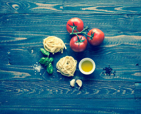 Tagliatelle with tomato and basil, made at home, on a wooden background. Top viewの写真素材