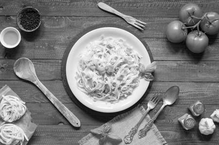 Tagliatelle with tomato and basil, made at home, on a wooden background. Top viewの写真素材