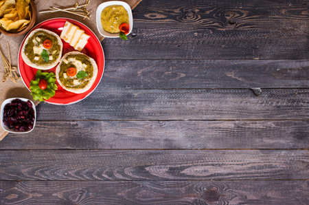 tasty and delicious bruschetta with avocado, tomatoes, cheese, herbs, chips and liquor, on a wooden background. Top viewの写真素材