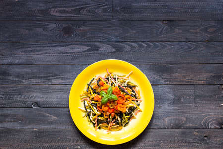 Delicious pasta with fresh vegetables and cheese, on a wooden background . Top viewの写真素材