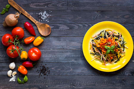 Delicious pasta with fresh vegetables and cheese, on a wooden background . Top viewの写真素材