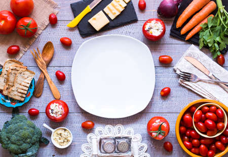 Stuffed tomatoes with cheese, and different vegetables, on a wooden background, free space for text.の写真素材