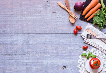 Stuffed tomatoes with cheese, and different vegetables, on a wooden background, free space for text.の写真素材