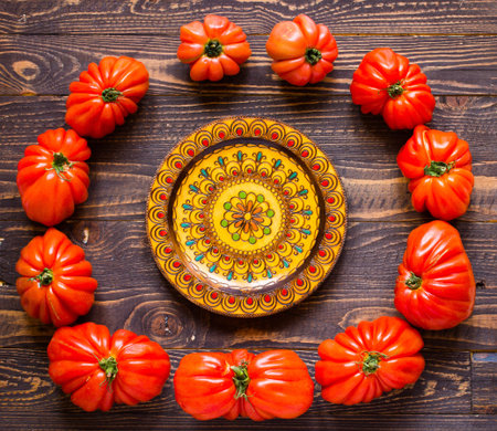 Ox heart tomatoes, on rustic wood background, free space for text. Top view