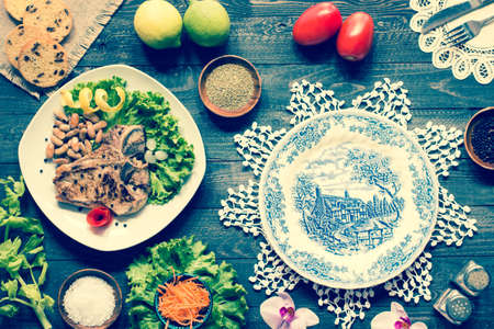 Pork steak homemade cooking with spices leaves lettuce on wooden cutting board, and a dish, on a wooden background,の写真素材