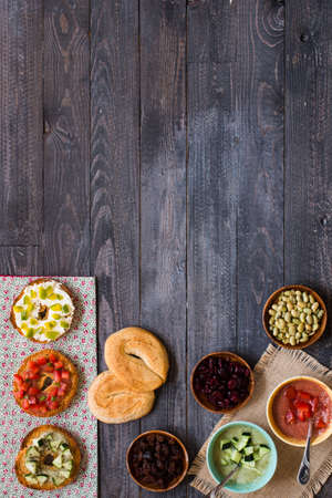 Italian bruschetta with cheese, tomato sauce, cucumber sauce, and herbs, on a wooden background. Top viewの写真素材