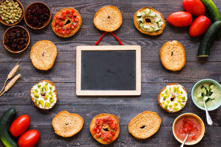 Italian bruschetta with cheese, tomato sauce, cucumber sauce, and herbs, on a wooden background. Top viewの写真素材