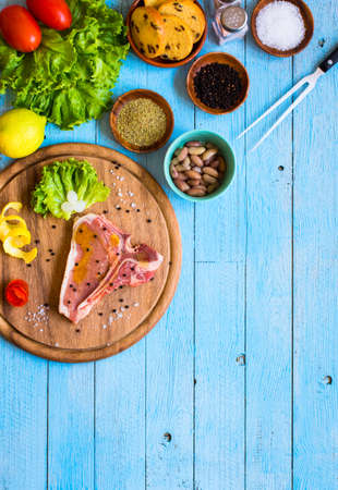 Pork steak homemade cooking with spices leaves lettuce on wooden cutting board, and a dish, on a wooden background,の写真素材
