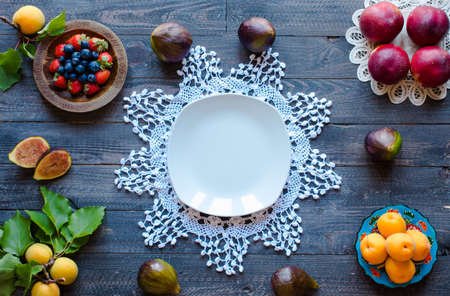 Fresh figs with peaches, apricots, blueberries, strawberries, on a wooden  background. with empty copy space close upの写真素材