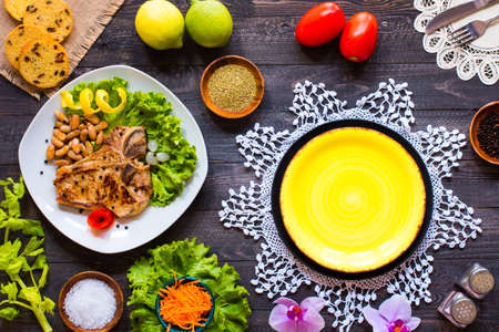 Pork steak homemade cooking with spices leaves lettuce on wooden cutting board, and a dish, on a wooden background,の写真素材