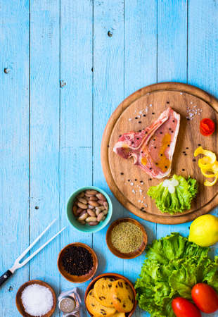 Pork steak homemade cooking with spices leaves lettuce on wooden cutting board, and a dish, on a wooden background,の写真素材