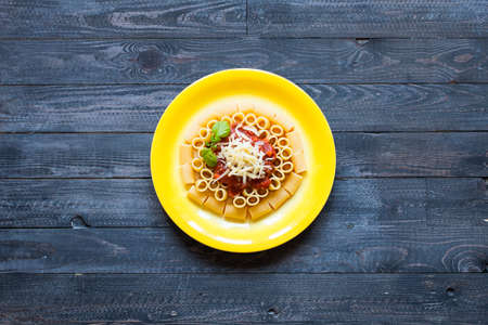 Top view of Italian pasta rigatoni with bolognese sauce, on a rustic wooden background. Top viewの写真素材
