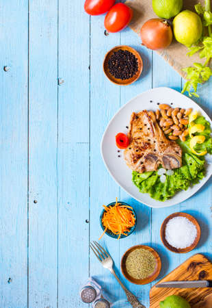 Pork steak homemade cooking with spices leaves lettuce on wooden cutting board, and a dish, on a wooden background,の写真素材
