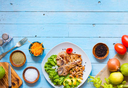 Pork steak homemade cooking with spices leaves lettuce on wooden cutting board, and a dish, on a wooden background,の写真素材