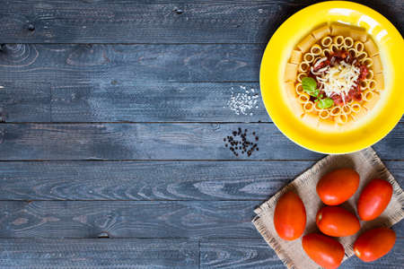Top view of Italian pasta rigatoni with bolognese sauce, on a rustic wooden background. Top viewの写真素材