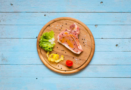 Pork steak homemade cooking with spices leaves lettuce on wooden cutting board, and a dish, on a wooden background,の写真素材