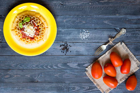 Top view of Italian pasta rigatoni with bolognese sauce, on a rustic wooden background. Top viewの写真素材