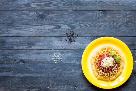 Top view of Italian pasta rigatoni with bolognese sauce, on a rustic wooden background. Top viewの写真素材
